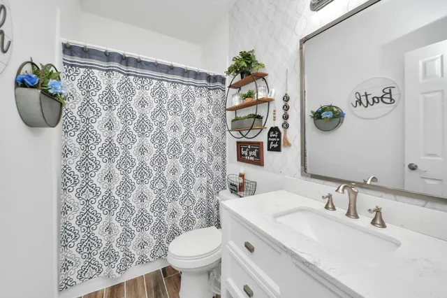 a bedroom with a bed and a flat tv screen on the dresser