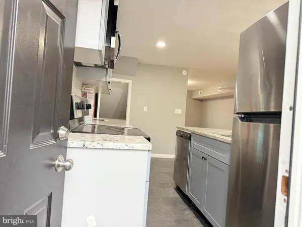 a kitchen with stainless steel appliances granite countertop a refrigerator and a stove top oven