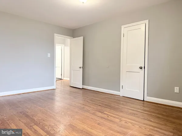 an empty room with wooden floor and closet
