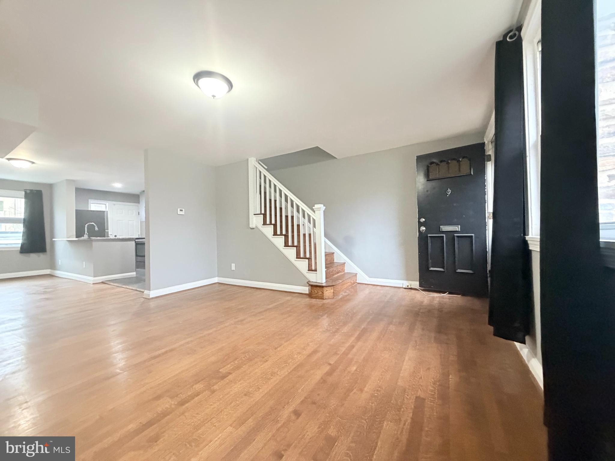 5115 Pembridge Avenue Baltimore, MD 21215 - Photo 4 of 29 a view of a hallway with wooden floor and a kitchen
