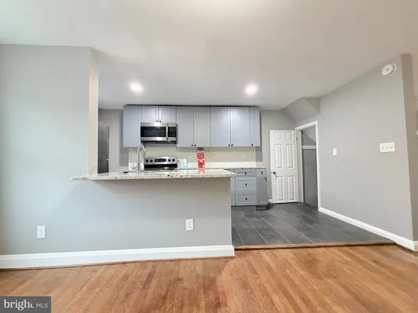 a kitchen with stainless steel appliances granite countertop a refrigerator a stove and a sink