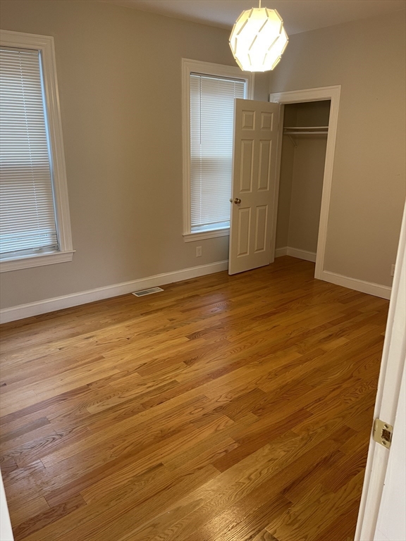79 Newton Street, Unit 79 Somerville, MA 02143 - Photo 11 of 24 a view of an empty room with wooden floor and a window