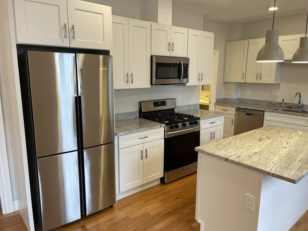 79 Newton Street, Unit 79 Somerville, MA 02143 - Photo 15 of 24 a kitchen with granite countertop a refrigerator stove and microwave