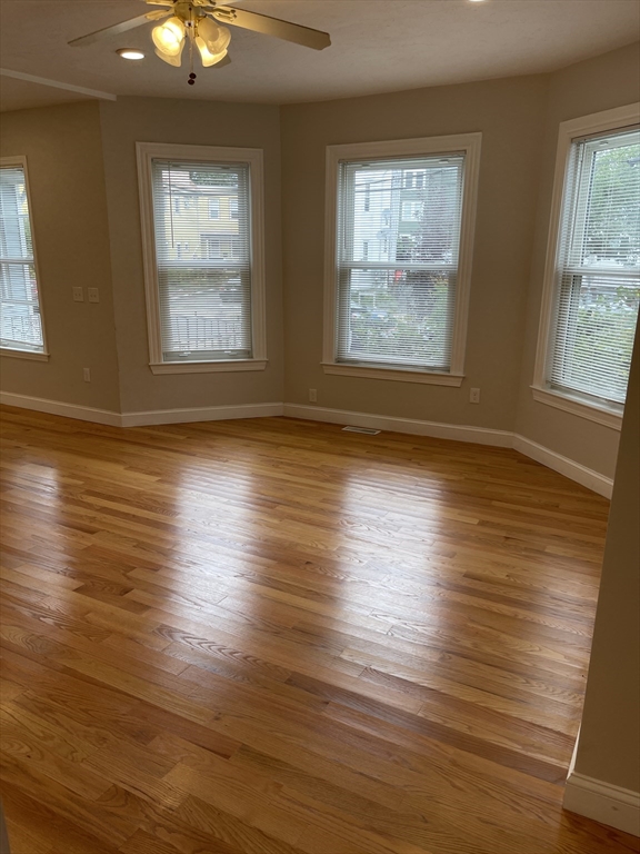 79 Newton Street, Unit 79 Somerville, MA 02143 - Photo 17 of 24 a view of an empty room with wooden floor and a window