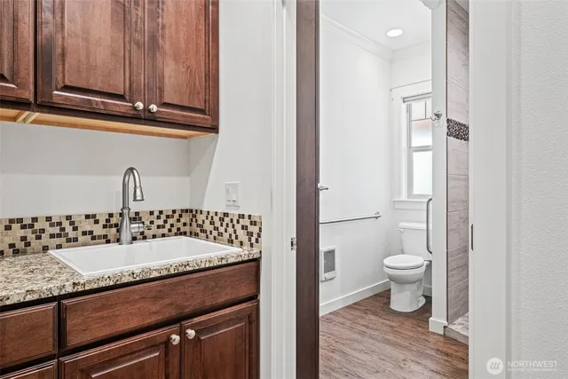 a bathroom with a granite countertop sink toilet and shower