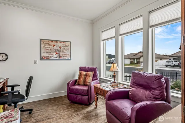 a living room with furniture a wooden floor and a large window