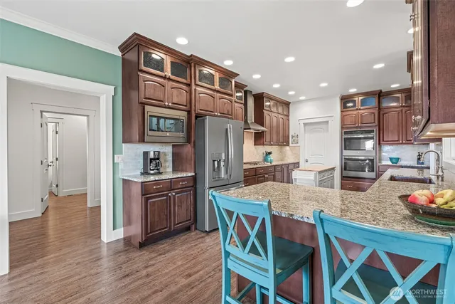 a kitchen with stainless steel appliances granite countertop a stove refrigerator and cabinets