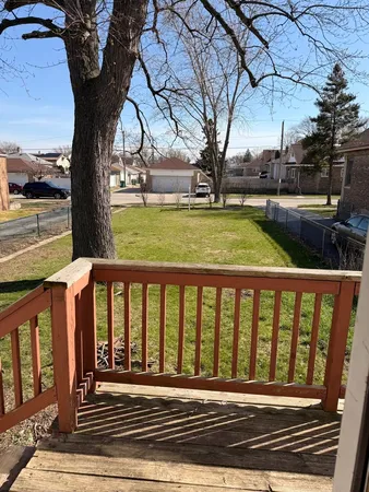 a view of a yard with wooden floor and fence