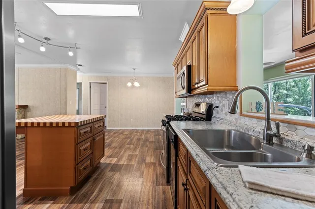a kitchen with stainless steel appliances granite countertop a sink stove and cabinets