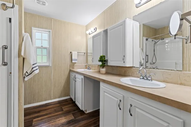 a bathroom with a double vanity sink mirror and shower