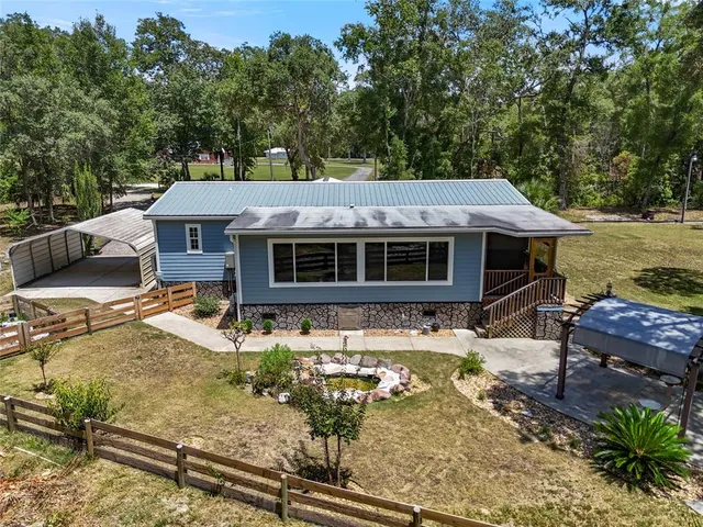a view of a house with backyard and sitting area