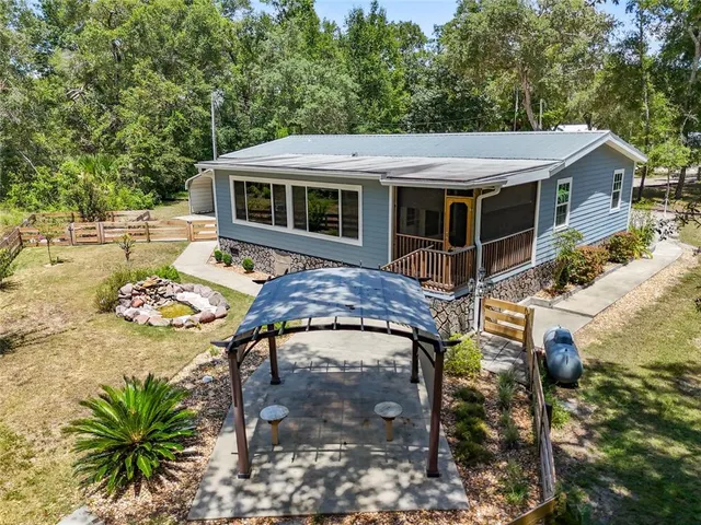 an aerial view of a house with swimming pool and sitting area