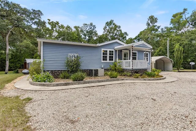 a front view of a house with a yard and potted plants