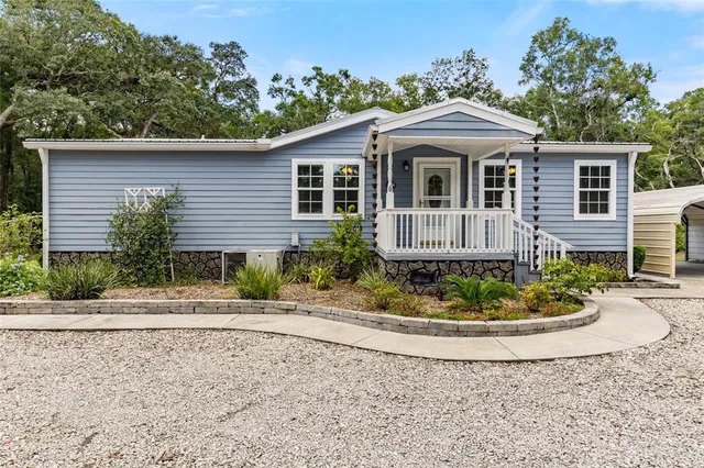 a view of a swimming pool with lawn chairs and plants