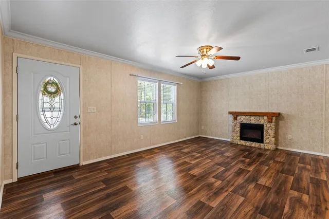 an empty room with windows and fireplace