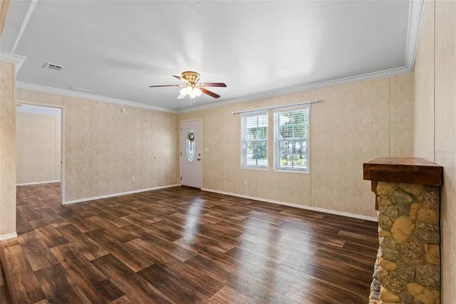 a view of an empty room with a window and wooden floor