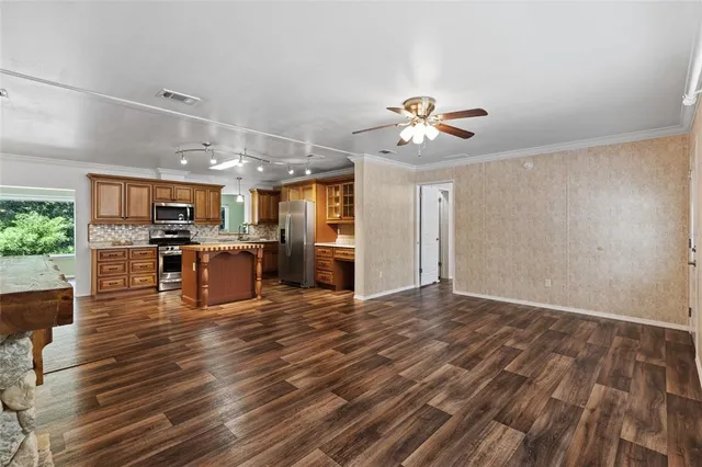 a view of kitchen with kitchen island microwave and wooden floor