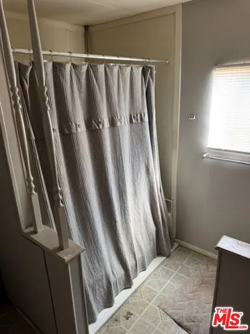 a bed sitting in a bedroom next to a window