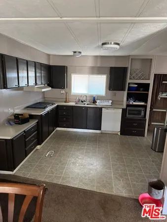 a kitchen with stainless steel appliances granite countertop a stove top oven a sink a counter space and cabinets