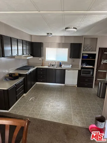 a kitchen with stainless steel appliances granite countertop a stove top oven a sink a counter space and cabinets