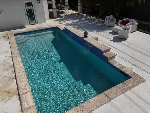 a view of a backyard with furniture and a garden
