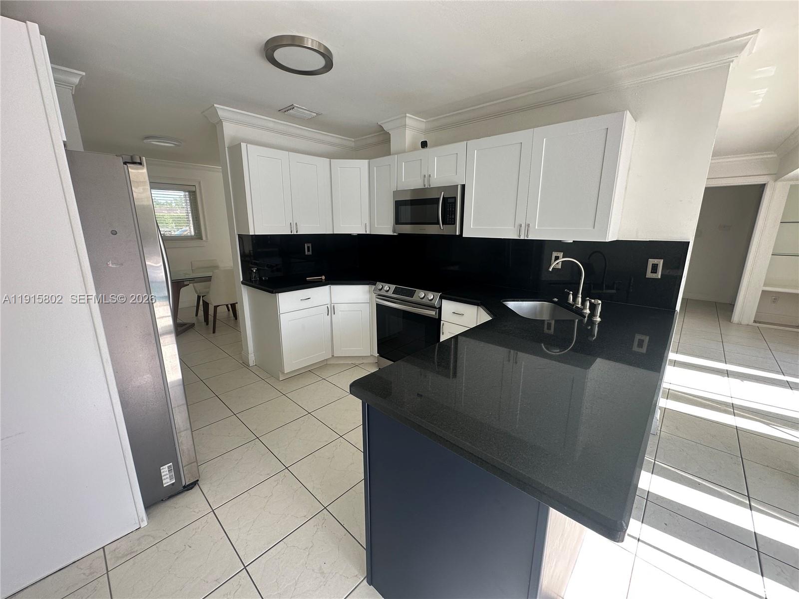 7780 Southwest 28th Street Miami, FL 33155 - Photo 16 of 54 a kitchen with a sink dishwasher a refrigerator and a microwave