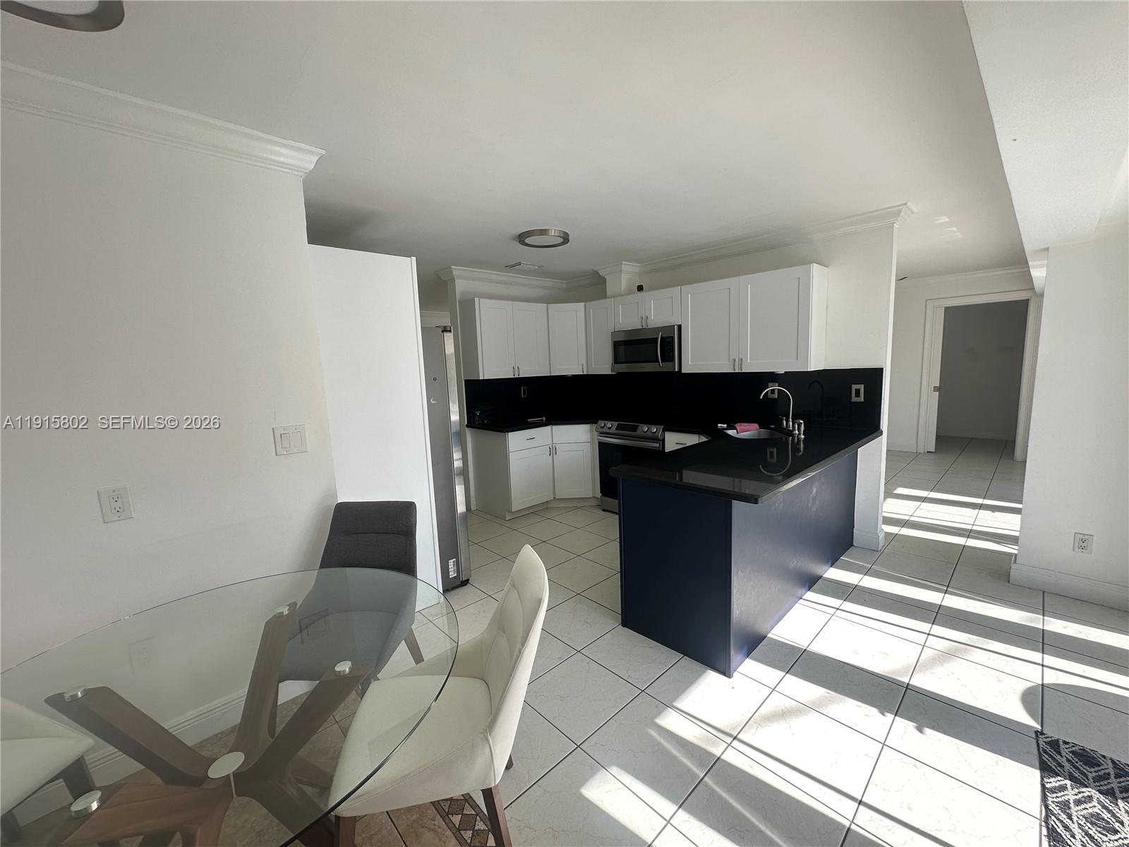 7780 Southwest 28th Street Miami, FL 33155 - Photo 17 of 54 a kitchen with stainless steel appliances kitchen island granite countertop a refrigerator and a stove top oven