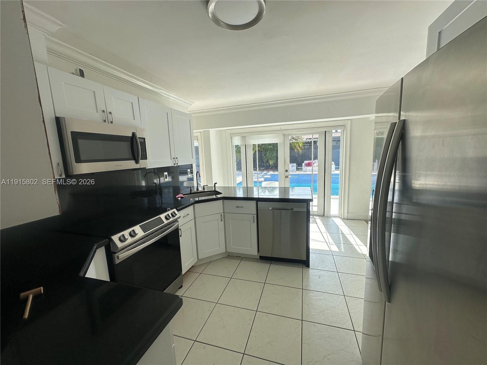 7780 Southwest 28th Street Miami, FL 33155 - Photo 19 of 54 a kitchen with stainless steel appliances granite countertop a refrigerator sink and stove