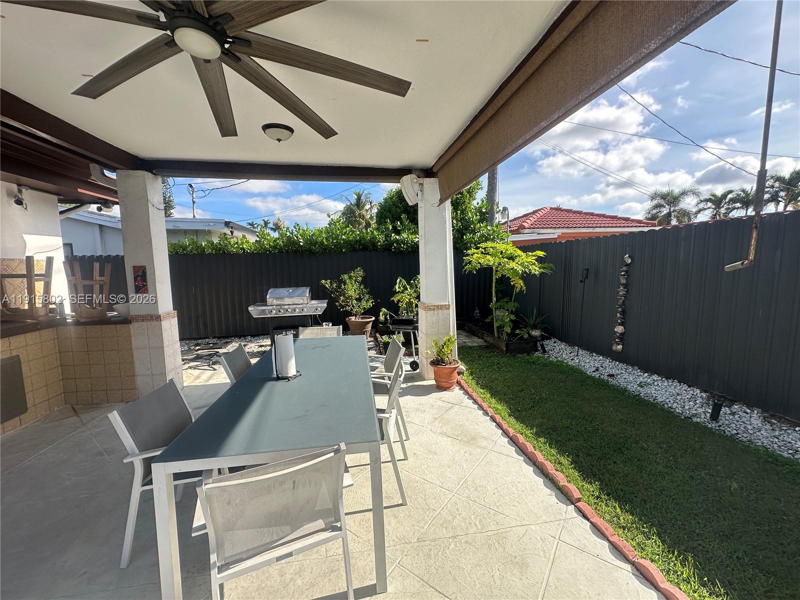 7780 Southwest 28th Street Miami, FL 33155 - Photo 41 of 54 a view of a patio with table and chairs potted plants with floor to ceiling window and wooden floor