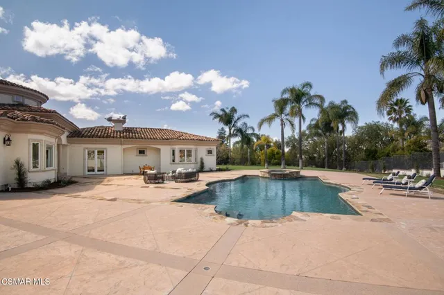 an aerial view of a houses with a lush green hillside