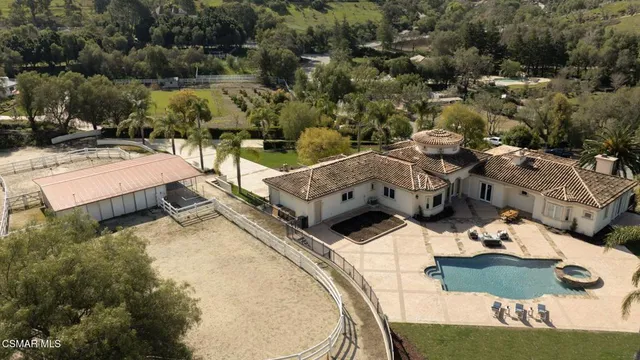 a front view of a house with a garden and lake view