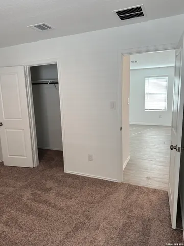a view of a hallway with wooden floor and closet area