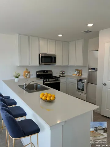 a kitchen with a sink a stove and chairs