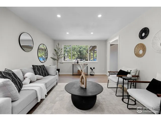 a living room with furniture a rug and a window