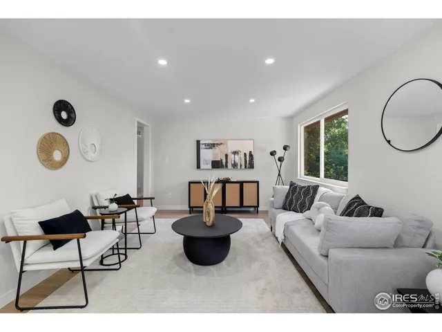 a living room with furniture a rug and a window