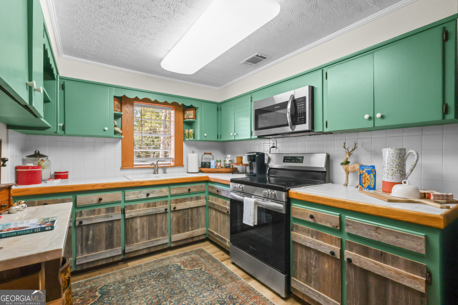 780 David Carter Road Baxley, GA 31513 - Photo 14 of 35 a kitchen with stainless steel appliances granite countertop a sink stove and cabinets