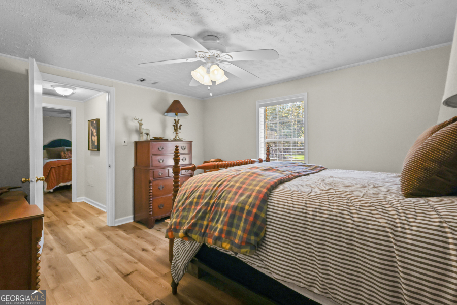 780 David Carter Road Baxley, GA 31513 - Photo 23 of 35 a bedroom with a large bed and a chandelier