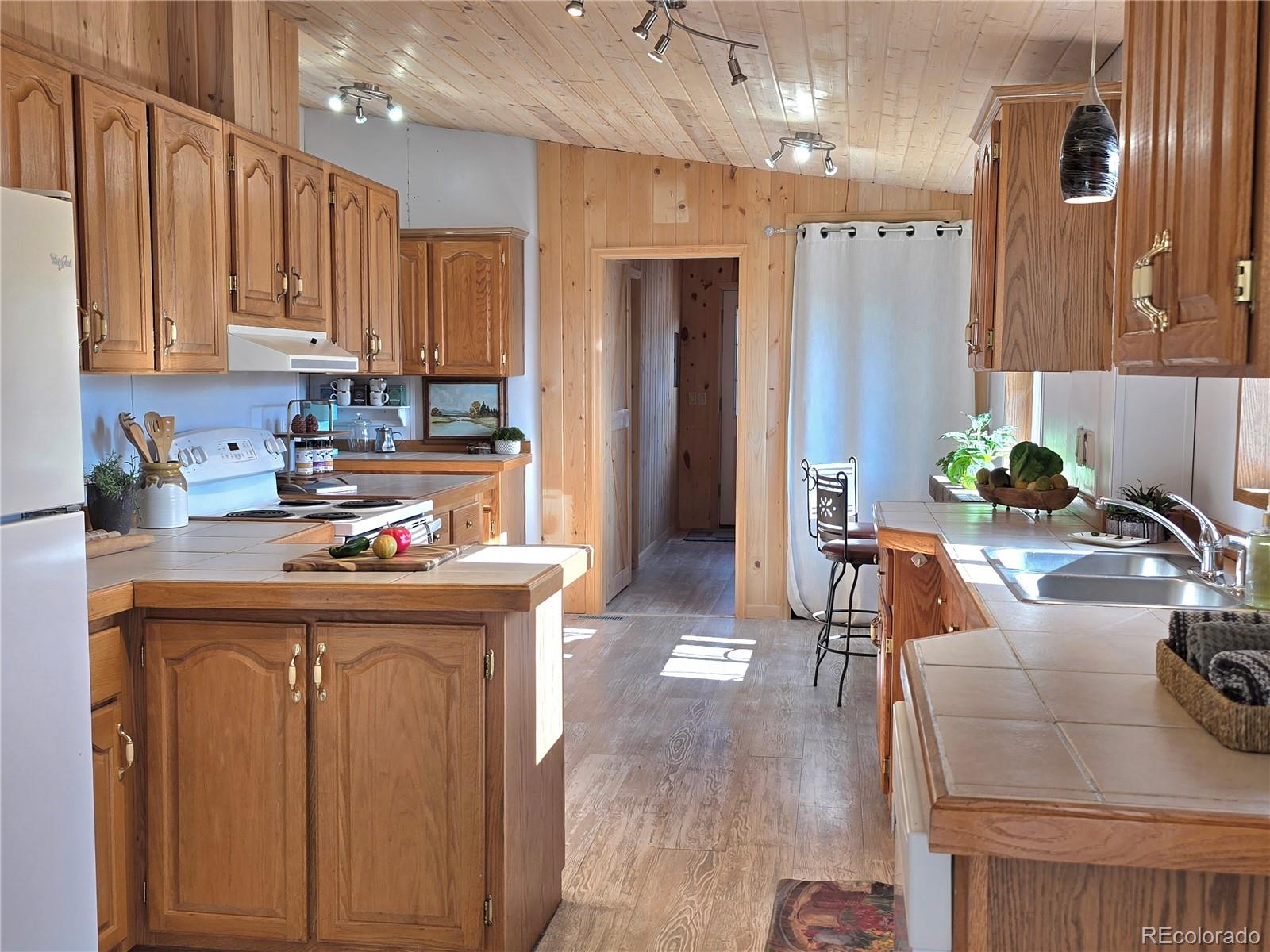 891 South Mountain Estates Road Florissant, CO 80816 - Photo 15 of 43 a kitchen with kitchen island granite countertop a sink stove and cabinets
