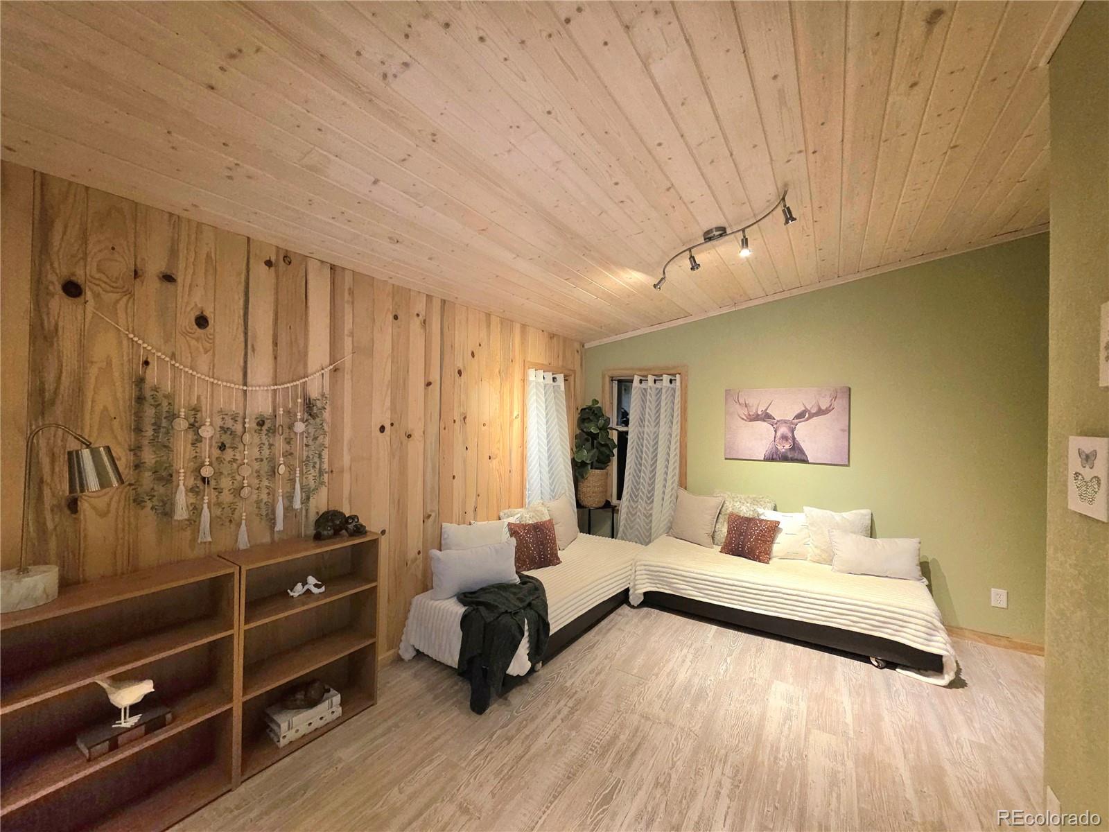 891 South Mountain Estates Road Florissant, CO 80816 - Photo 22 of 43 a spacious bedroom with a bed and a dresser