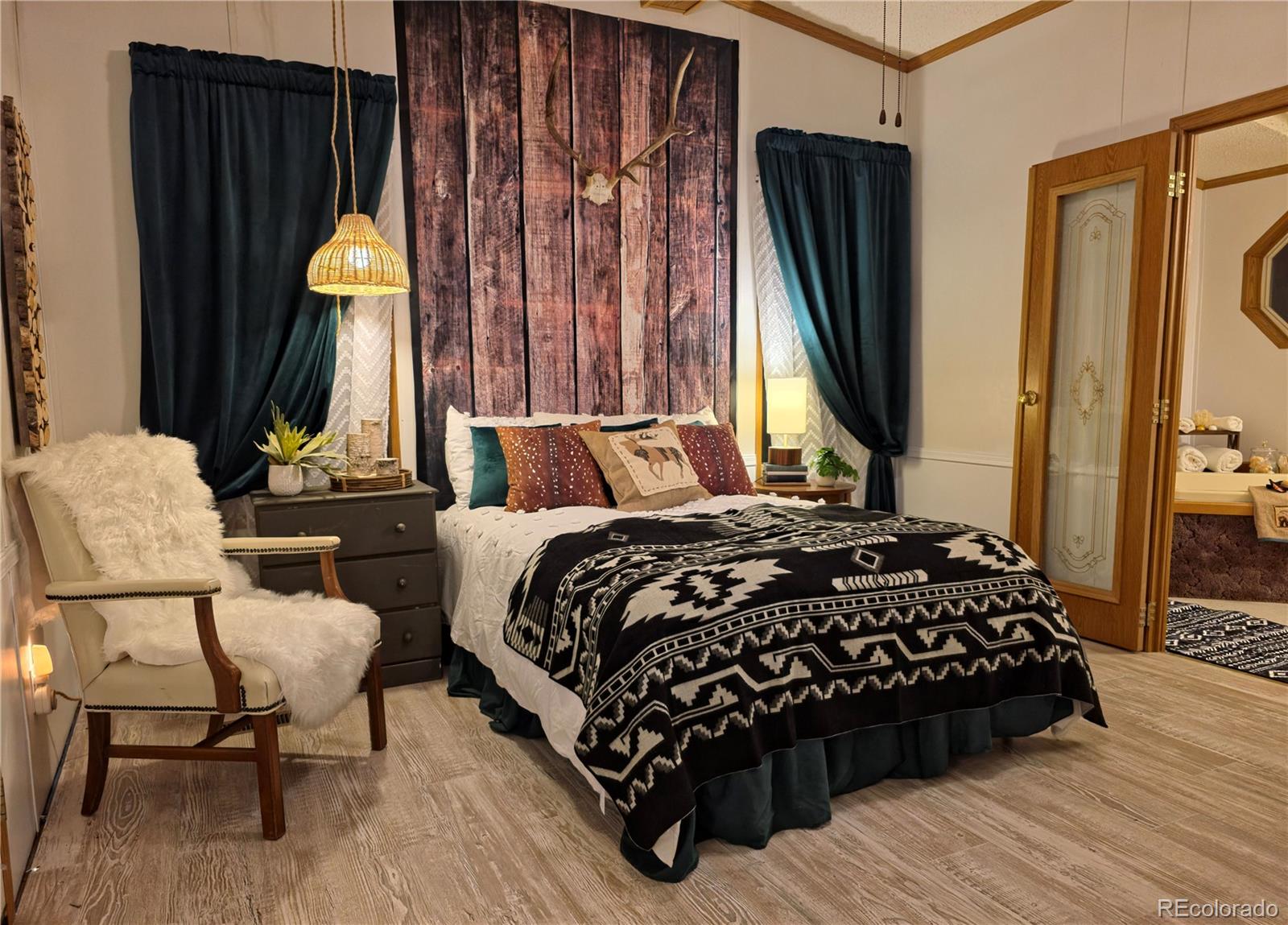 891 South Mountain Estates Road Florissant, CO 80816 - Photo 24 of 43 a bedroom with a bed and chair with the wooden floor