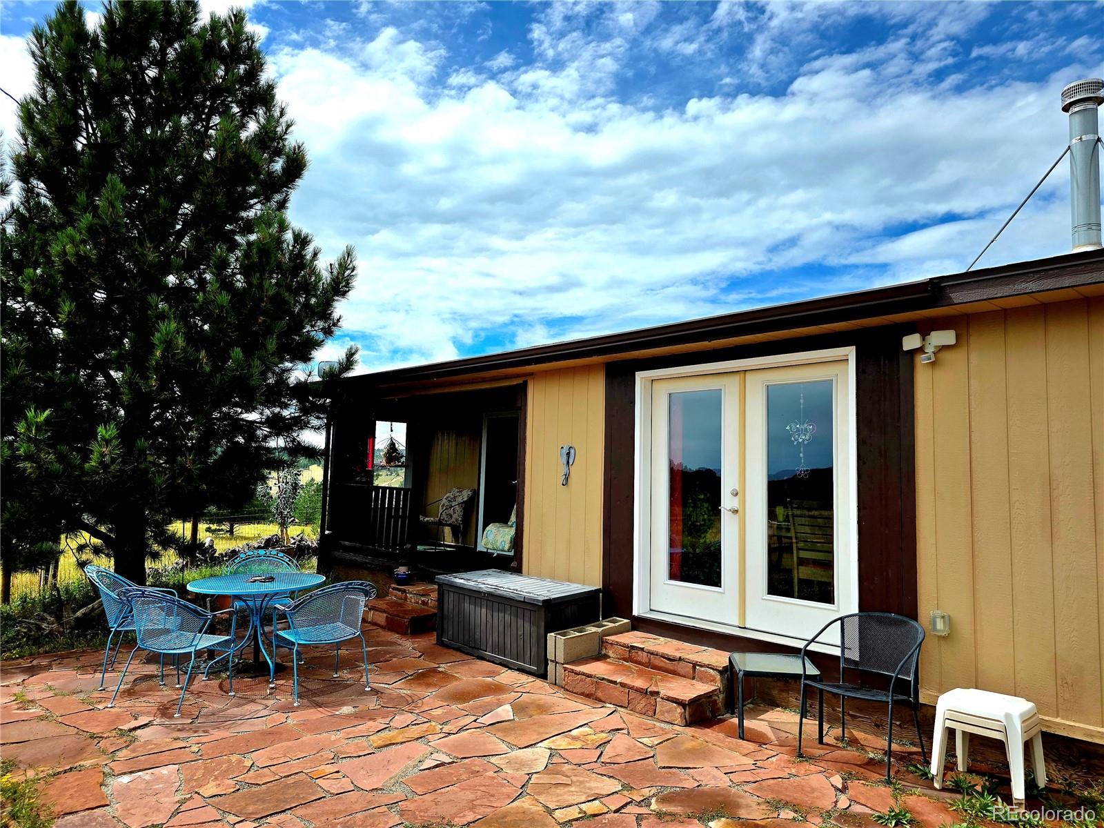 891 South Mountain Estates Road Florissant, CO 80816 - Photo 30 of 43 a backyard of a house with outdoor seating