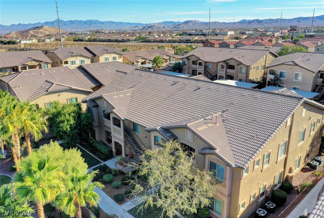 8985 South Durango Drive, Unit 2187 Las Vegas, NV 89113 - Photo 43 of 73 An aerial perspective reveals the expansive tile roofing of multiple residential structures within a serene desert community.