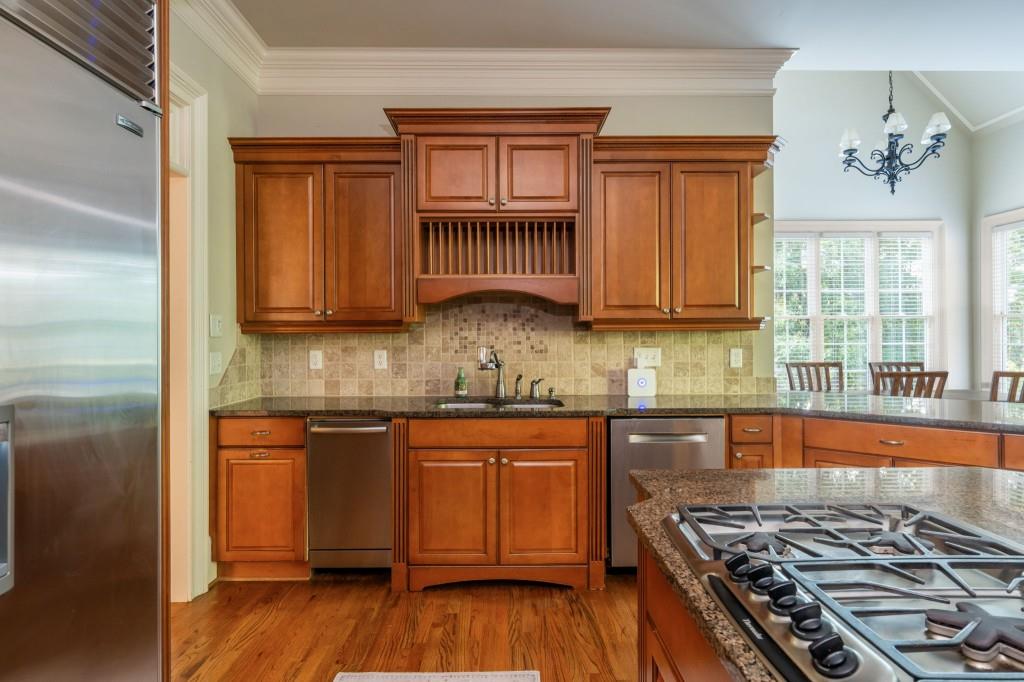 220 Edwards Brook Court Canton, GA 30115 - Photo 29 of 77 a kitchen with stainless steel appliances granite countertop a stove a sink dishwasher and a microwave oven with wooden floor