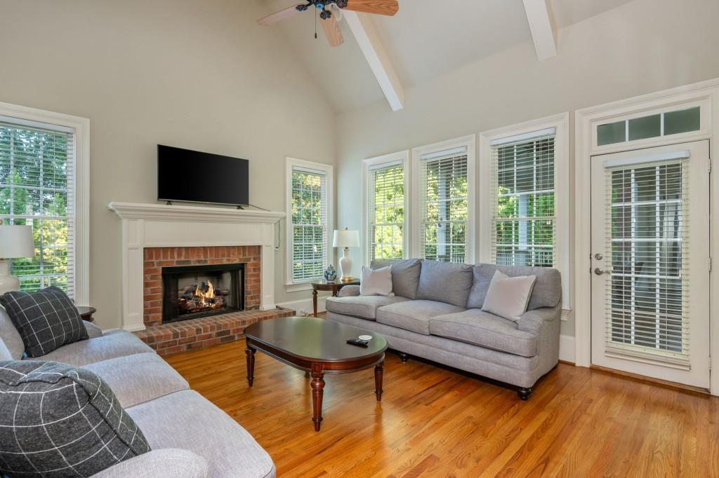 220 Edwards Brook Court Canton, GA 30115 - Photo 34 of 77 a living room with furniture a fireplace and a floor to ceiling window