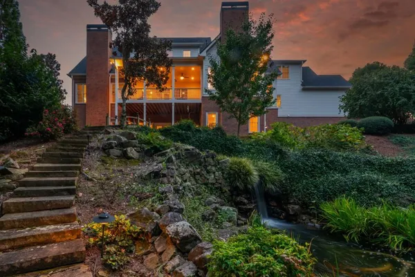 a front view of a multi story residential apartment building with yard and green space