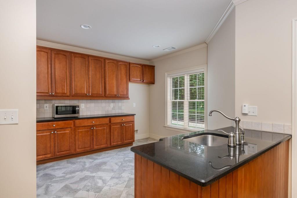 220 Edwards Brook Court Canton, GA 30115 - Photo 56 of 77 a kitchen with granite countertop a sink window and cabinets