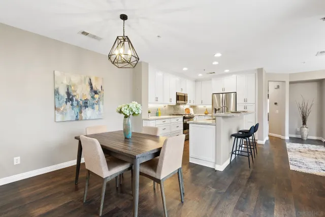 a kitchen with a table chairs refrigerator and microwave