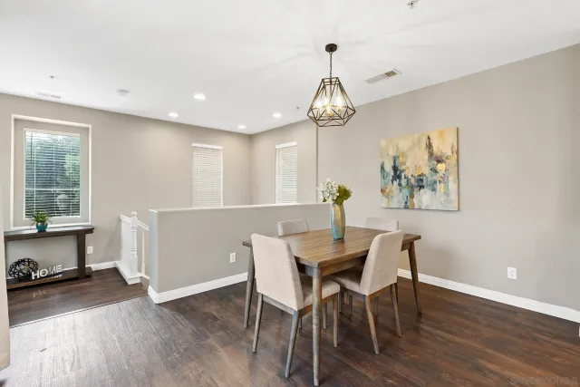 a living room with furniture kitchen view and a wooden floor
