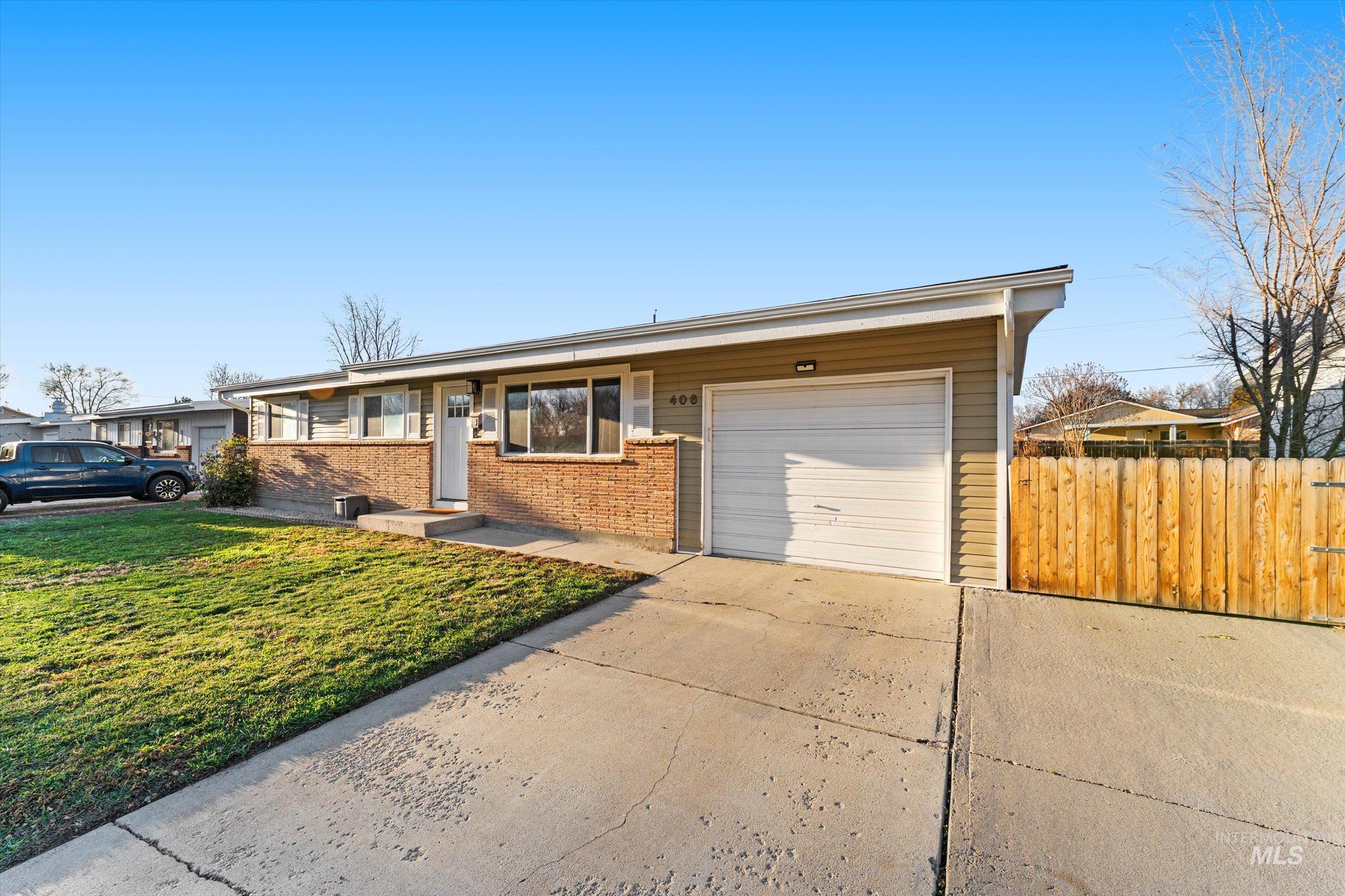 Ranch-style house featuring concrete driveway, brick siding, and an attached garage