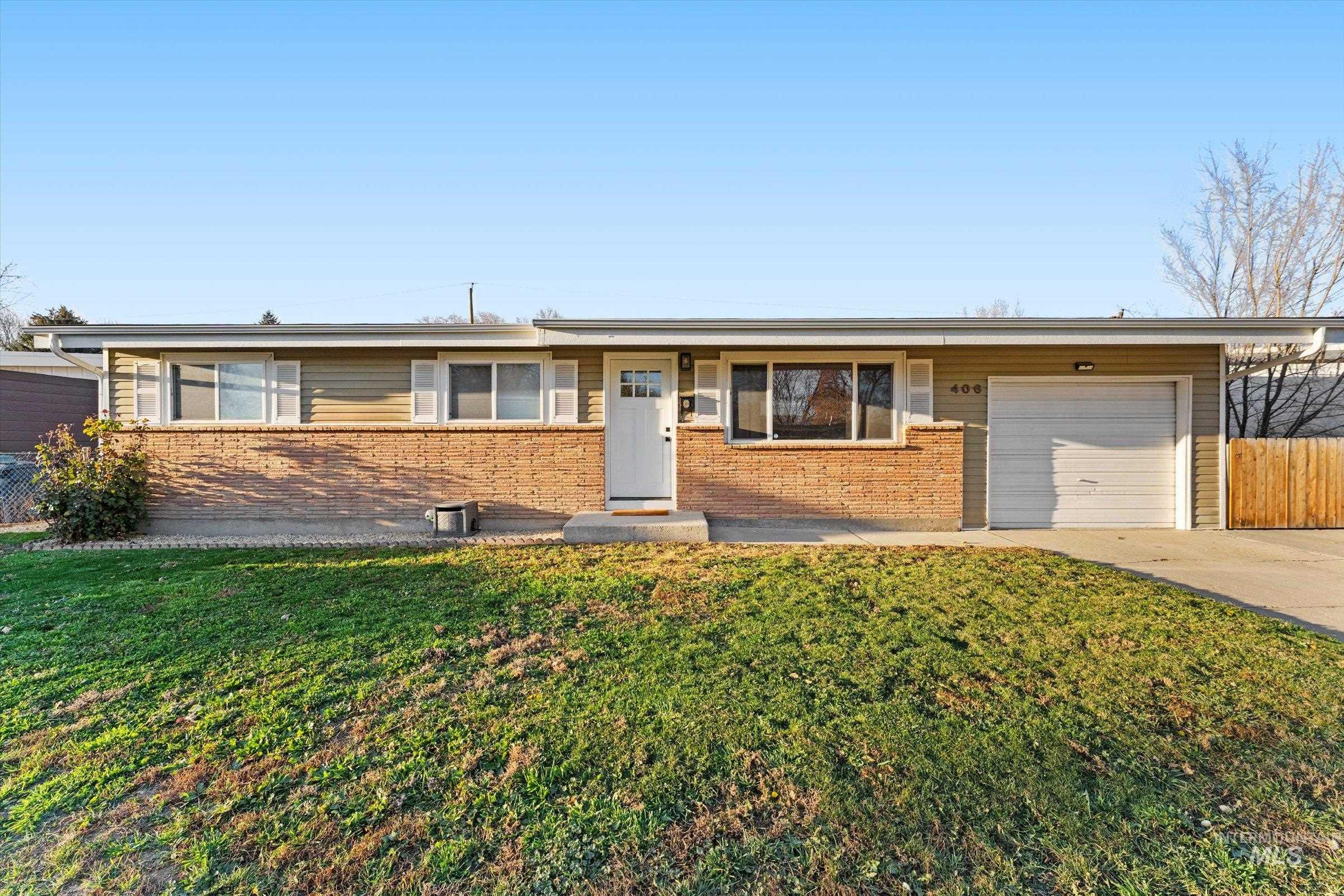 406 Chestnut Street Mountain Home, ID 83647 - Photo 30 of 31 Ranch-style home with an attached garage, brick siding, and driveway
